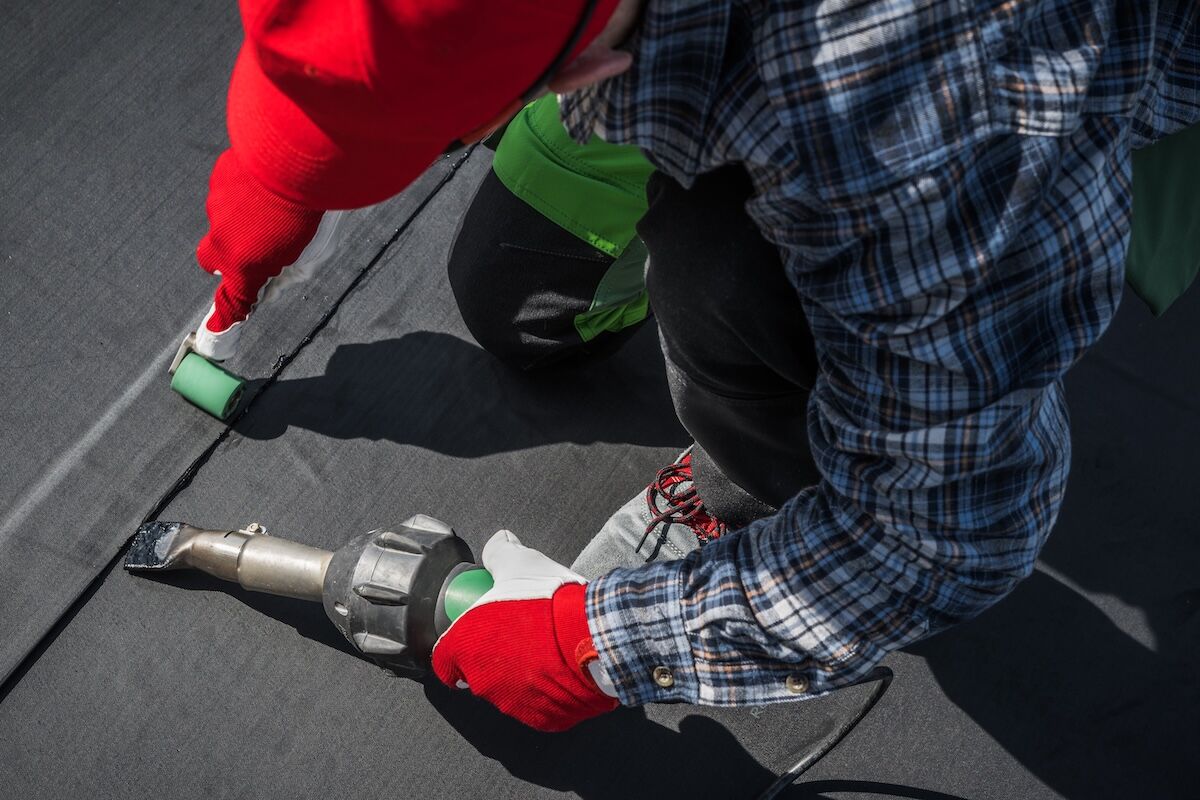 EPDM Ethylene Propylene Diene Terpolymer Material being installed on industrial roof