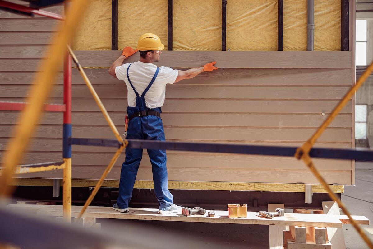 Worker installing textured vinyl siding