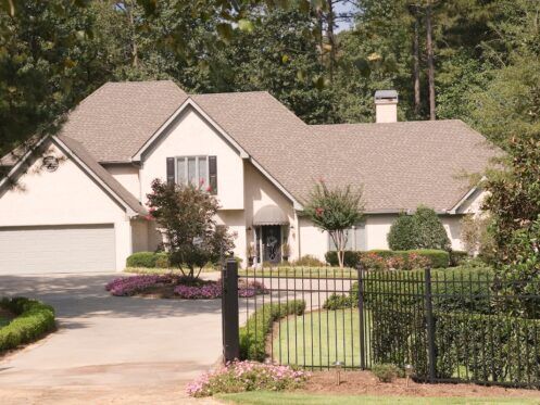 A nice stucco house behind an iron fence