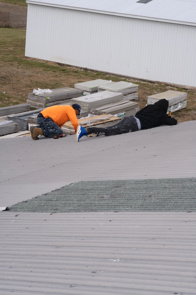 roofers working on metal roof
