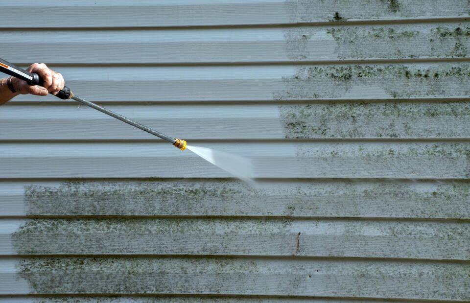 how to clean vinyl siding-person using a power washing tool to clean vinyl siding