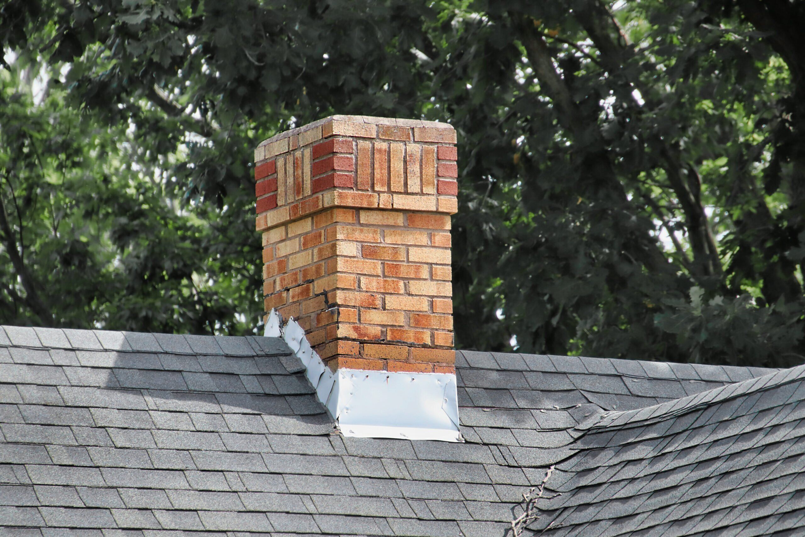 old chimney with silver flashing surrounding base