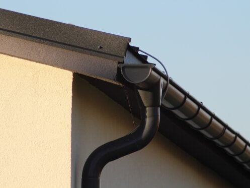 black metal gutter that matches roofing