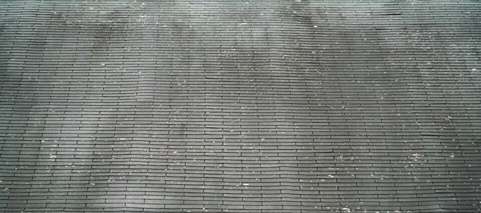 black streaks on roof-close up of roof with dirty patches and streaks on shingles