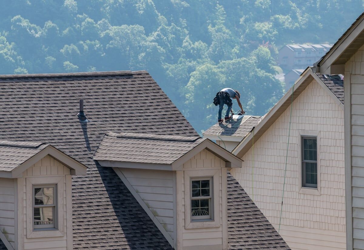 roofer replacing asphalt shingles