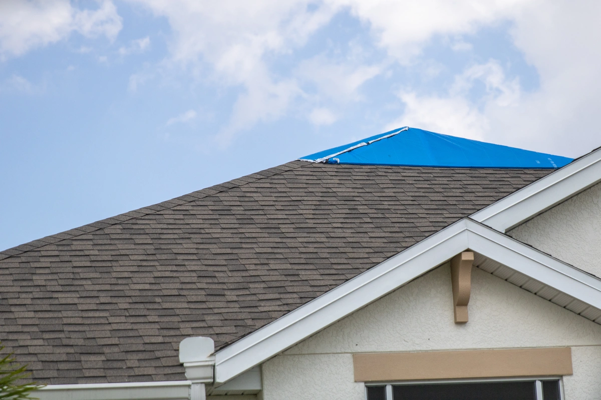 peak of a roof that was covered by a blue tarp after an emergency