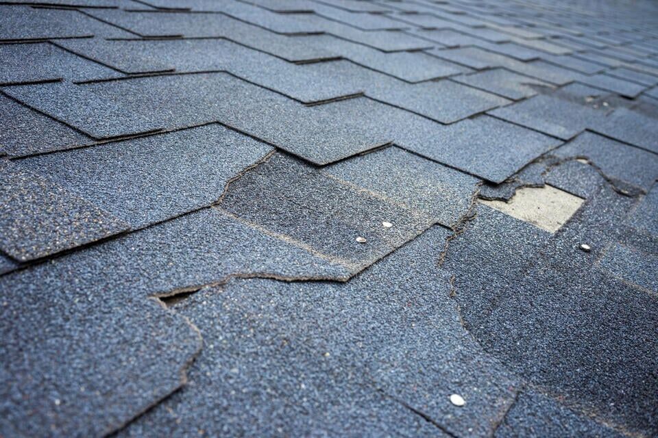 roof repair vs replacement-close up of damaged shingles that need to be replaced