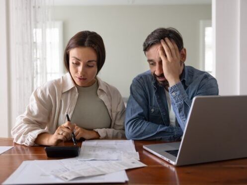 concerned couple looks stressed reviewing paperwork
