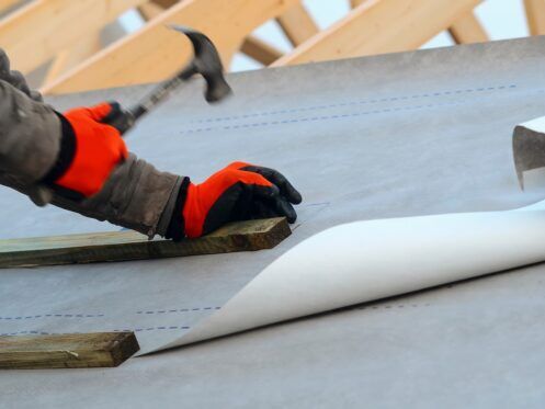 Joiner working on a new house roof making it ready for roof tiles or slates